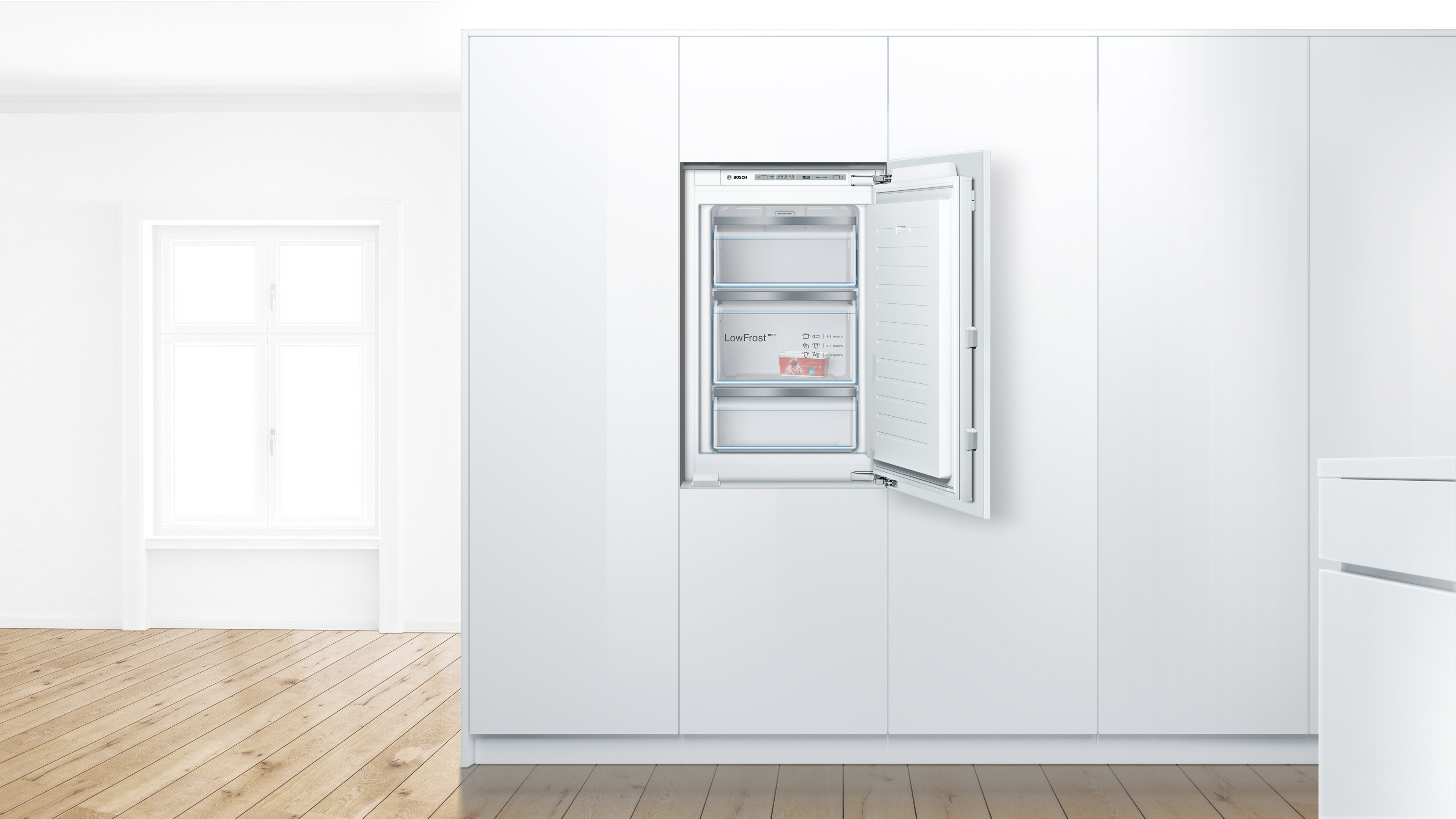Built in fridge with open door showing shelves and freezer compartments in a white kitchen cabinet wall  globalmtc