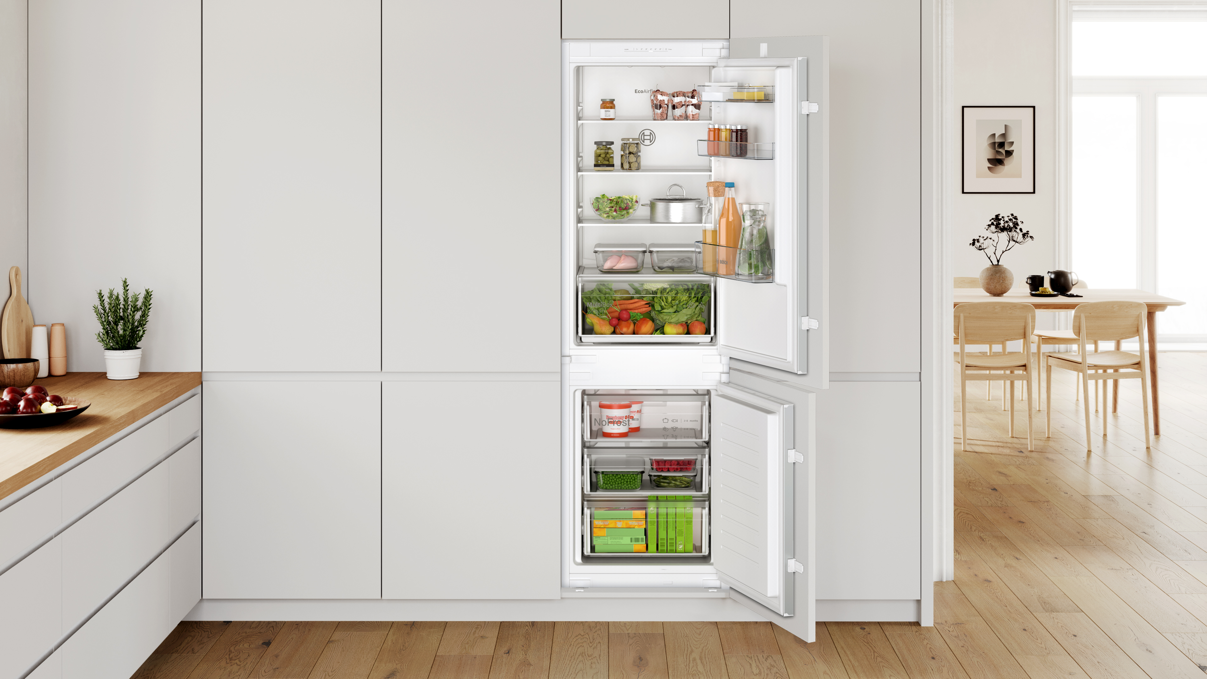 Open refrigerator in a modern grey kitchen showing organized shelves with jars bottles greens and vegetables Globalmtc
